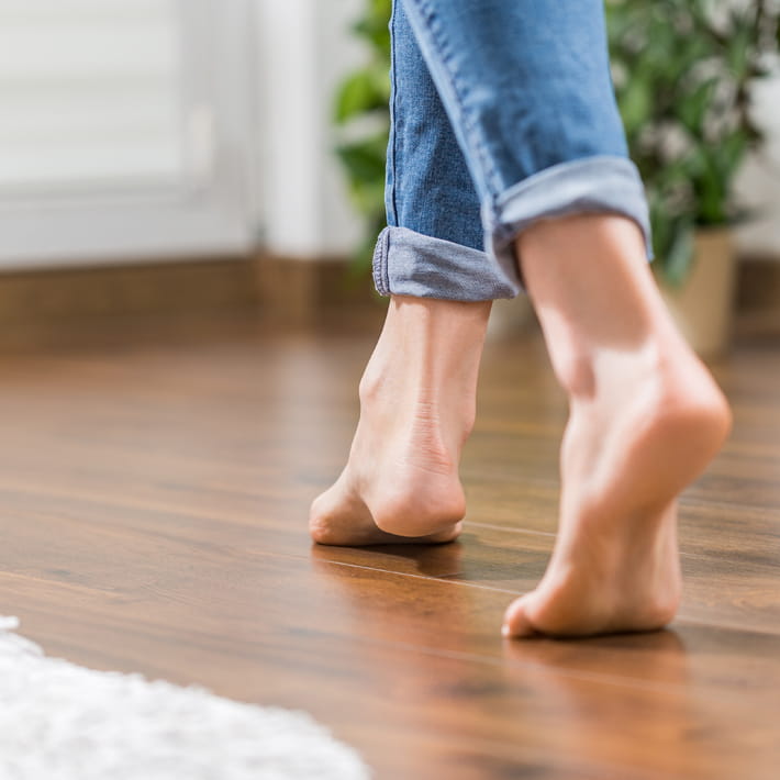 Barefeet walking on wooden floor