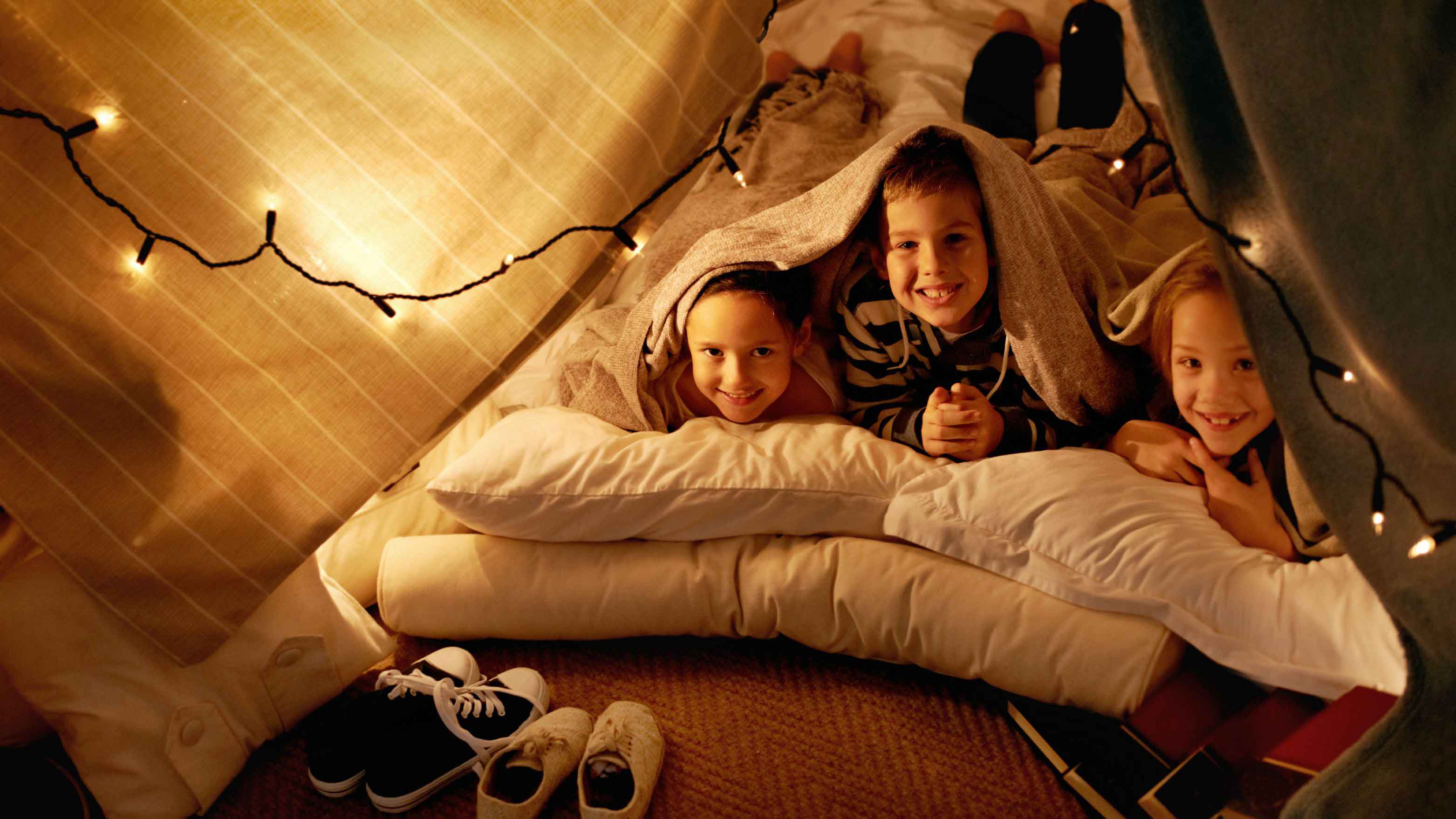 children playing underneath tent fort