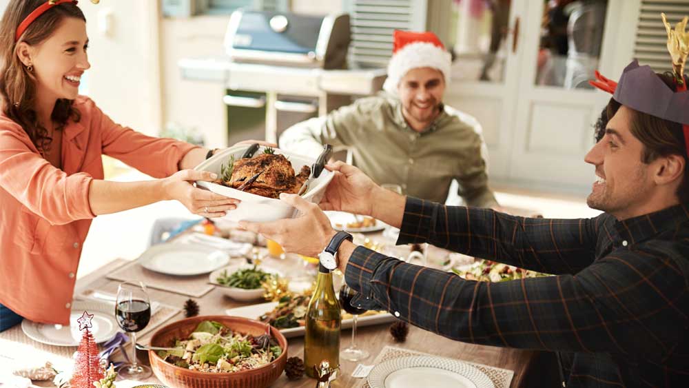 People enjoying Christmas dinner around the table