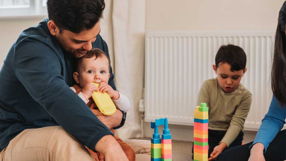 Father and young son playing in front of a gas radiator