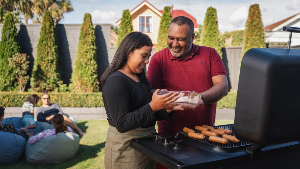 father and daughter cooking on BBQ