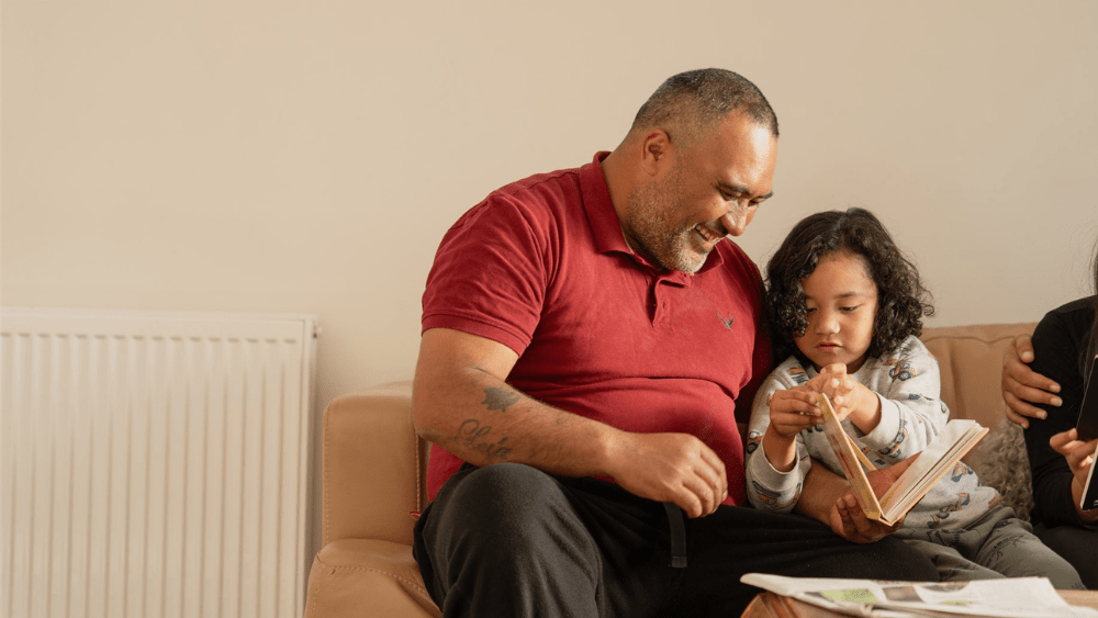 Father and son reading on the couch.