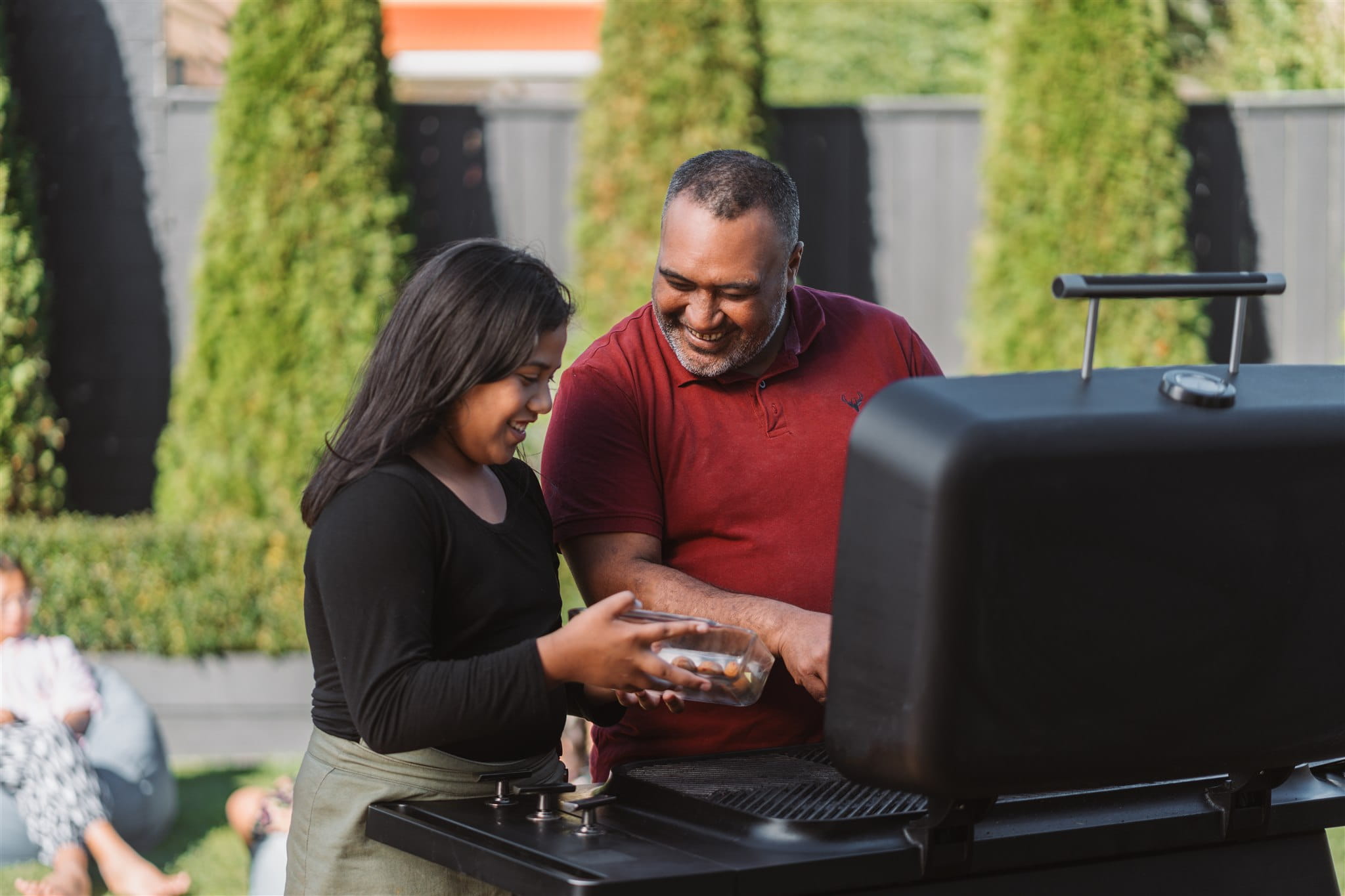 Couple cooking on gas grill