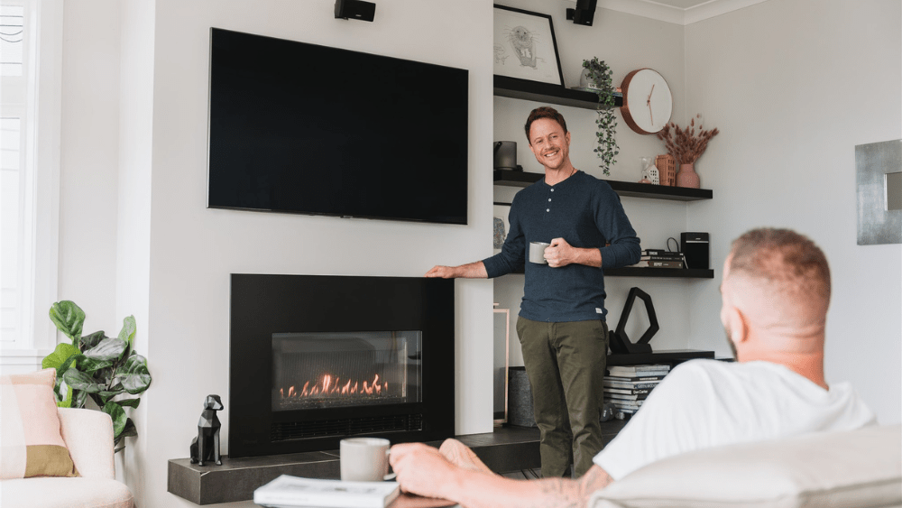 Two people enjoying the heat from a natural gas fire.