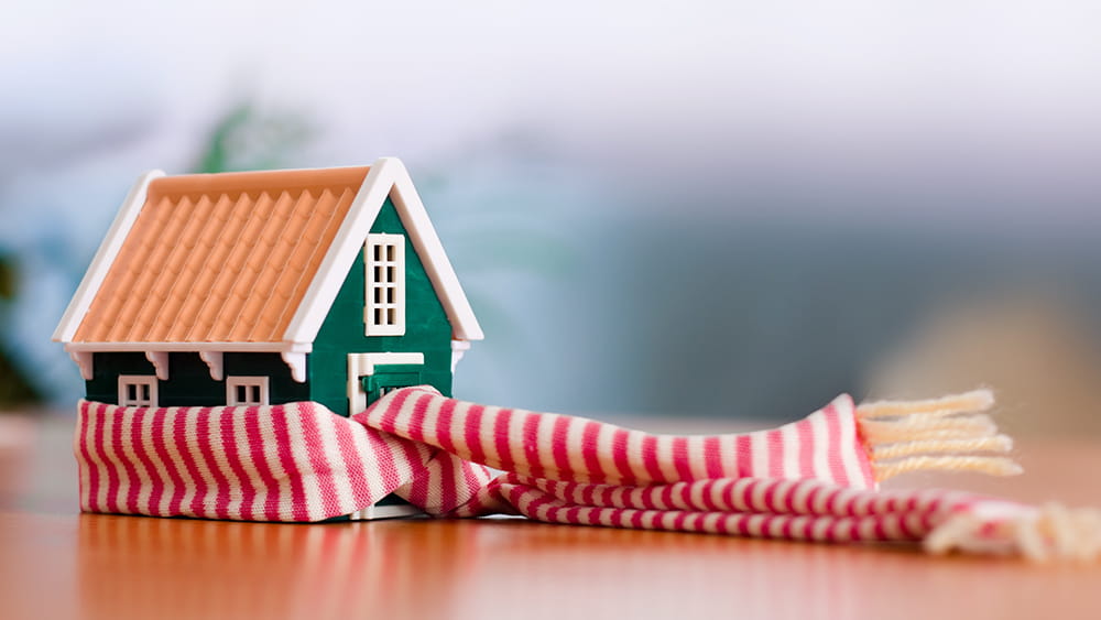 Miniature house wrapped in scarf